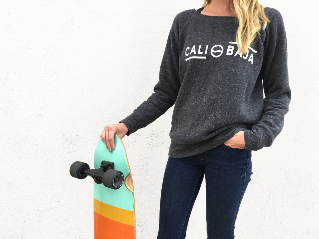 Jess with skateboard and Cali Baja sweatshirt