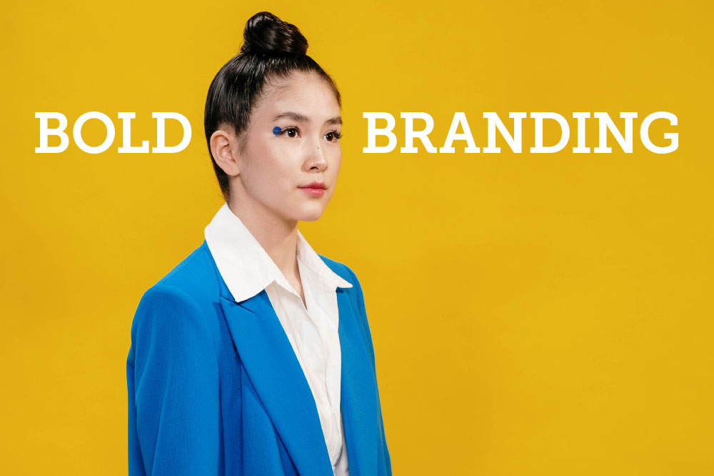 Woman wearing an electric blue blazer with the words "Bold Branding"